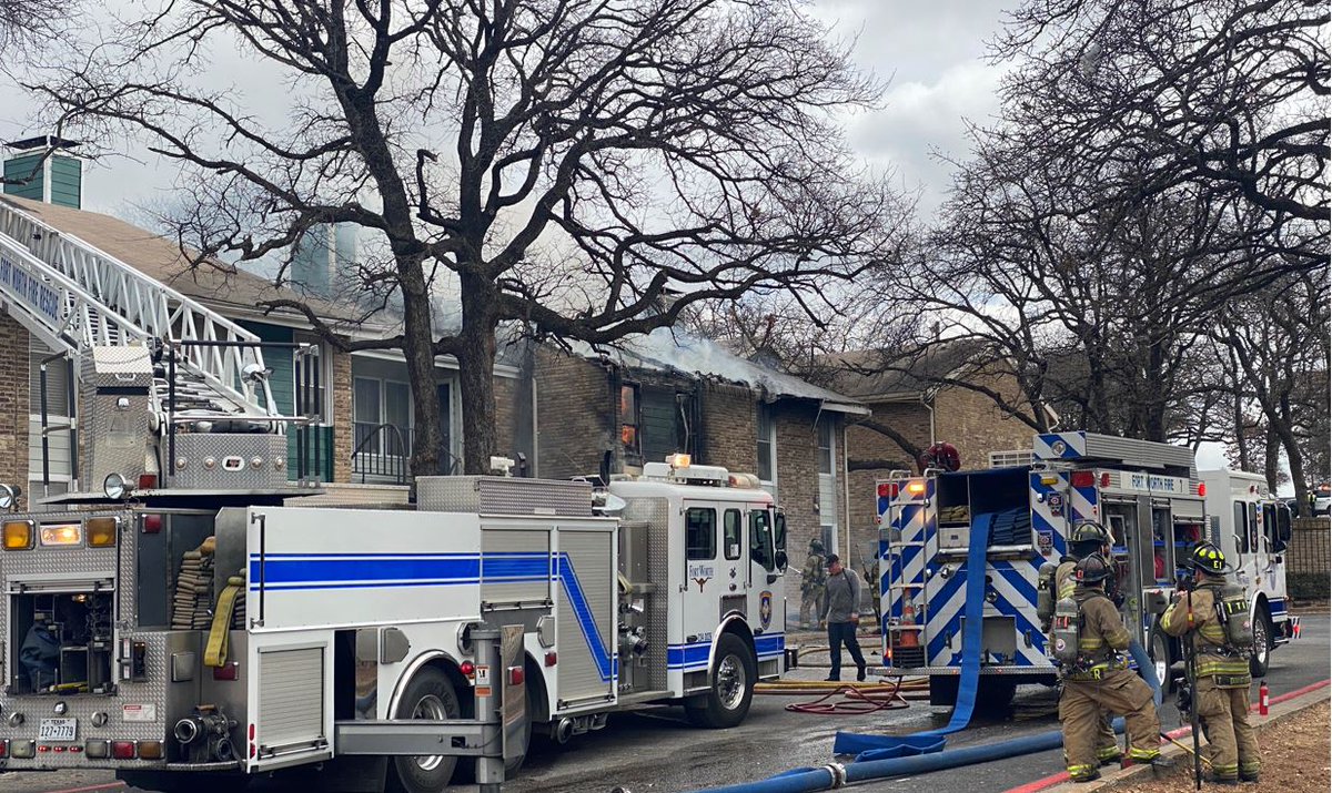 Officials say a fire in a 2-story Fort Worth apartment building engulfed both floors and spread to the attic Tuesday morning. Two people were treated for smoke inhalation