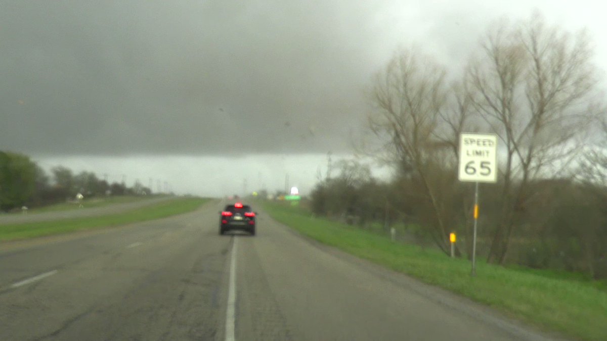 Tornado crossing the road in front of me near Elgin, TX. The debris is from a mobile home that was destroyed. One person was taken away by ambulance