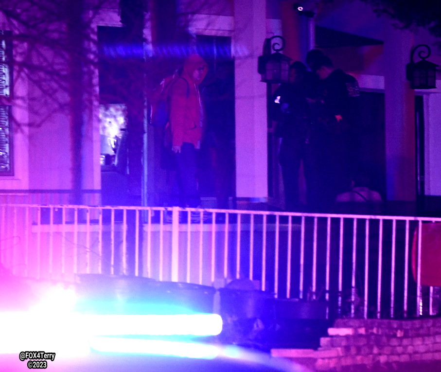 Dallas police apply a tourniquet after a woman is wounded by gunfire inside her West Dallas home. Police say multiple shooters fired into the home. 