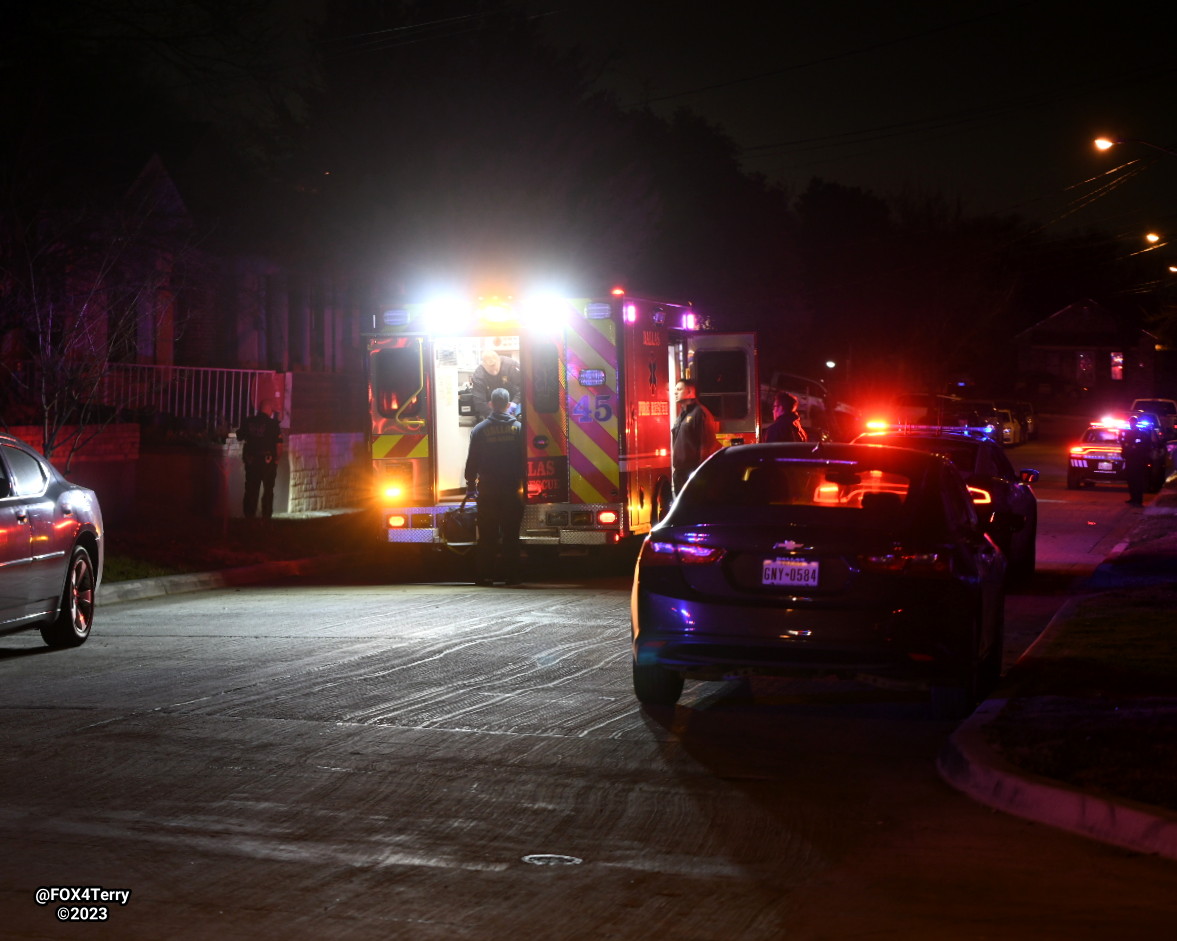 Dallas police apply a tourniquet after a woman is wounded by gunfire inside her West Dallas home. Police say multiple shooters fired into the home. 